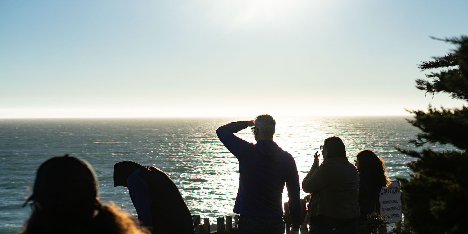 A group watches the sun set from Whale Watch Point at Gualala Point Regional Park