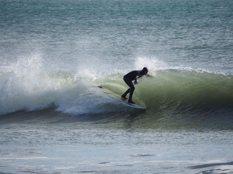 surfer rides a wave at Doran Beach