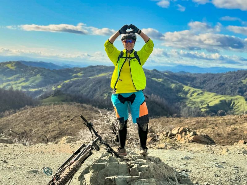 mountain biker stands at viewpoint on top of Hood Mountain