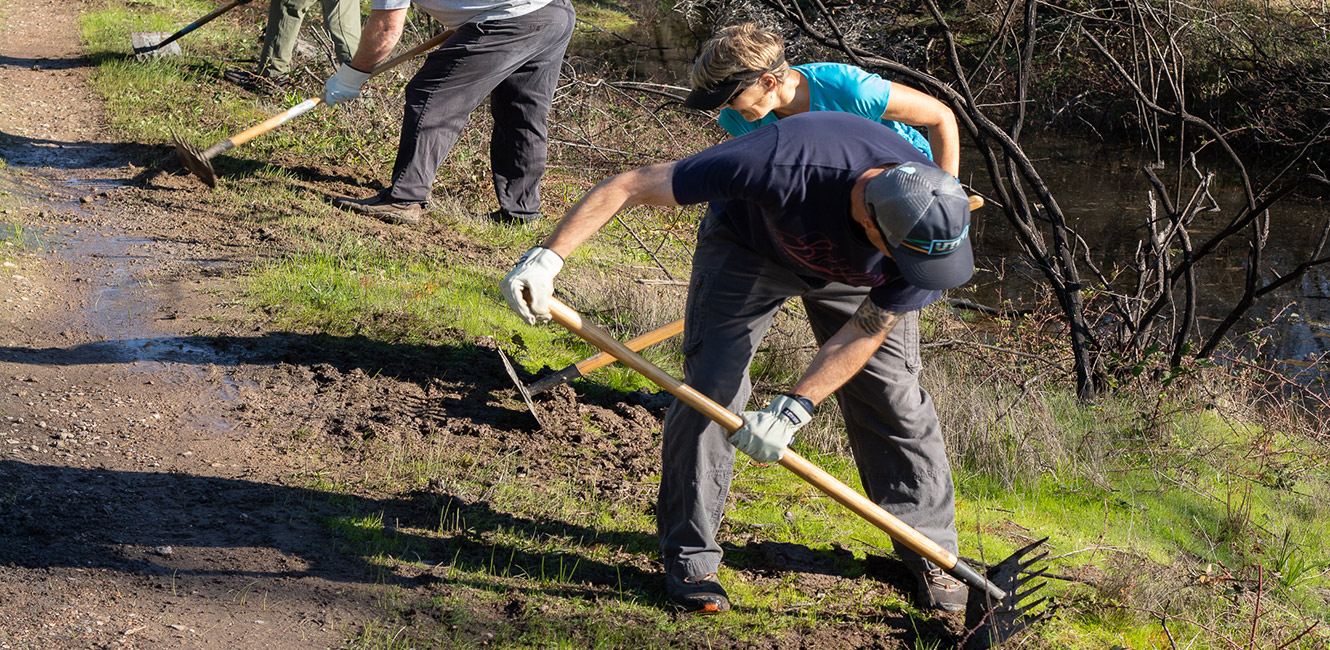 People raking trail