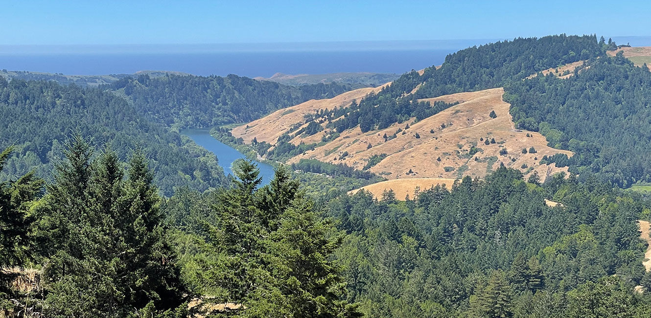 Monte Rio Redwoods Regional Park & Open Space Preserve. View looks west of the Russian River as it heads to the mouth just south of Jenner. In the background, a light fog layer over the ocean.